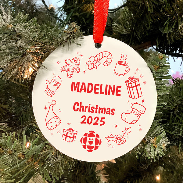 Round Christmas ornament with 'MADELINE Christmas 2025' text and festive icons on a tree.